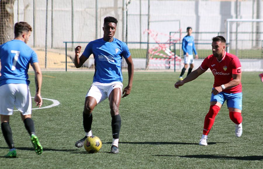 El colombiano Carlos Ramírez golpea el balón ante su compañero Óscar Baldomero y el capitán del Guadiaro. 