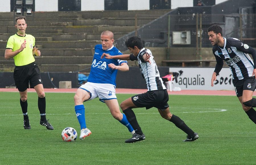 Lolo González controla el balón ante dos rivales y el colegiado