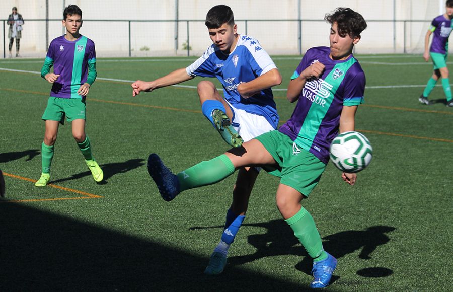 Álvaro Núñez, del cadete B del San Fernando CD, golpea el balón ante un jugador del Sporting Puertorrealeña. 