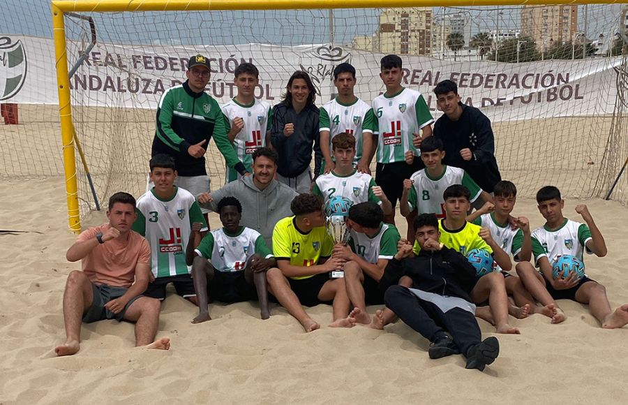 El CD Pastora posó con el trofeo de campeón provincial., que besan dos jugadores.