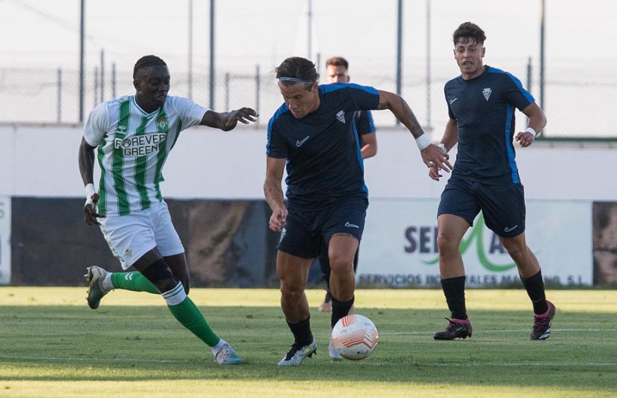 Dani Aquino controla el balón ante un jugador del Betis Deportivo.