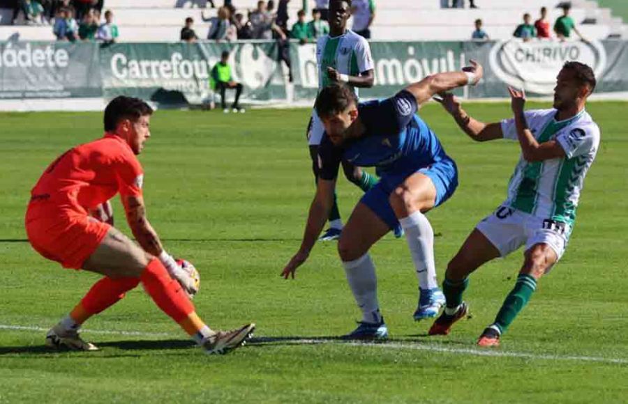 El meta del San Fernando CD Diego Fuoli se hace con balón ante Carlos Blanco y Luismi Gutiérrez, autor del empate del Antequera. 