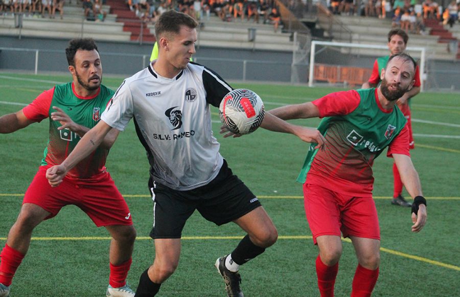 Moisés Fonseca, delantero del San Fernando Atlético, controla el balón ante el marcaje de dos jugadores del CD Benalup.