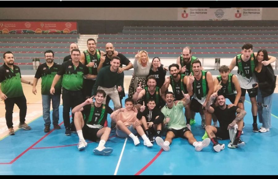 Los jugadores y el staff técnico del CB San Fernando celebran el triunfo conseguido en Dos Hermanas y con su presidenta María Gómez Paredes exultante de alegría