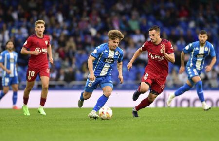 Álvaro Arnedo, con el Linares, intenta frenar a Mario Soriano en Riazor. A la izquierda, el azulgrana Fermín. 