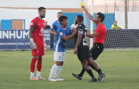 El colegiado Sáez Vital amonesta al meta del San Fernando CD Ángel de la Calzada tras el rifirafe que tuvo con Jalid, al que frena Javi López. 