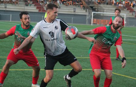 Moisés Fonseca, delantero del San Fernando Atlético, controla el balón ante el marcaje de dos jugadores del CD Benalup.