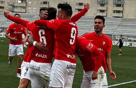 Dani Molina levanta los brazos en señal de júbilo y, a la vez, es felicitado tras marcar el 0-2 hace dos temporadas en La Línea. 