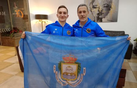 Yerai Amado y su entrenador Pachi Arce, con una bandera del CN San Fernando. 